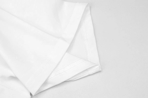 Dettaglio ravvicinato dell'orlo a doppia cucitura e trama in cotone di una t-shirt bianca