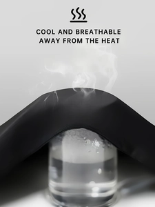 Close-up of black breathable cotton vest fabric showing steam passing through for cool effect