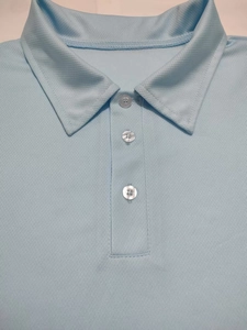 Close-up of light blue men's Polo shirt collar with breathable honeycomb fabric texture