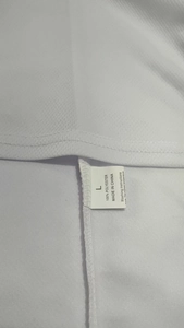Detailed view of 100% polyester fabric texture and care label for men's polo set