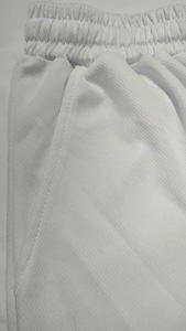 Close-up of white sports shorts featuring breathable mesh fabric and elastic waistband