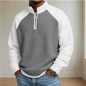 Détail du tissu gaufré et du col zippé sur ce polo pour homme gris et blanc