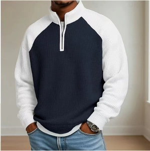 Détail du tissu gaufré et du col zippé sur ce polo bleu marine à manches raglan