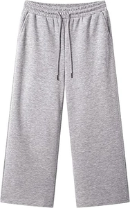 Dettaglio dei pantaloni grigi a gamba larga con trama in maglia e vita elastica con coulisse