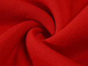 Close-up of bright red knitted loopback cotton fabric texture for luxury hoodies