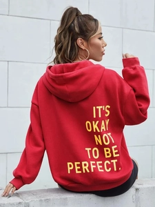 Detail der roten Hoodie-Rückseite mit gelbem Text IT'S OKAY NOT TO BE PERFECT.