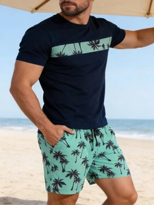 Nahaufnahme von dunkelblauem T-Shirt mit Palmenprint und passenden Strandshorts