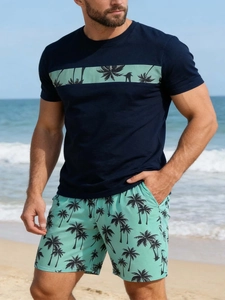 Detail eines blauen Herren-T-Shirts mit Palmenstreifen und dazu passenden Strandshorts