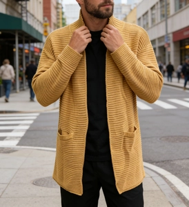 Détail de la texture en maille côtelée jaune moutarde du cardigan avec ses poches avant