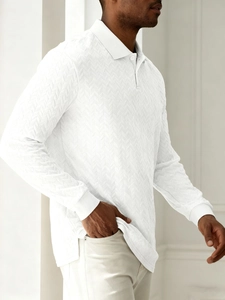 Detail view of white long-sleeved polo shirt showing textured herringbone fabric and rib cuff