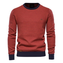 Close-up of waffle knit texture on slim fit V-neck sweater with navy blue ribbed cuffs