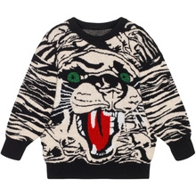 Detail of kids knit sweater featuring a bold black and white tiger pattern and green eyes