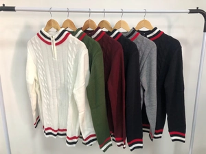 Detail showing various colors of cable-knit half-zip sweaters with striped ribbed cuffs