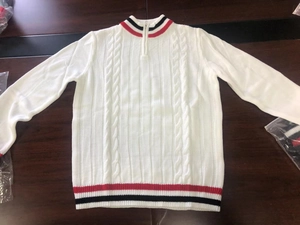 Detailed macro view of white knit sweater featuring classic red and black stripe collar accents