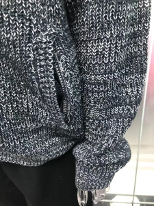 Close-up of thick grey knit cardigan featuring side pocket and textured sleeve cuff