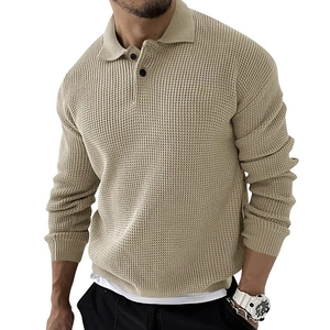 Detail van de wafelgebreide textuur en zwarte knopen op de beige slim fit polo