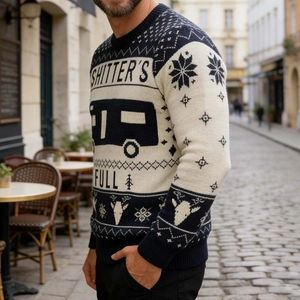 Close-up of knitted men's Christmas sweater with elk motifs and humorous text on street