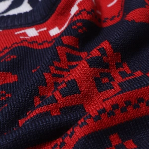 Détail de la maille épaisse avec des motifs jacquard festifs rouges et bleus sur le pull