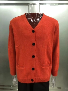 Vue détaillée du cardigan en maille avec col en V, deux poches latérales et grands boutons noirs