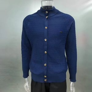 Detail of navy blue knit cardigan featuring a stand collar and gold metal buttons