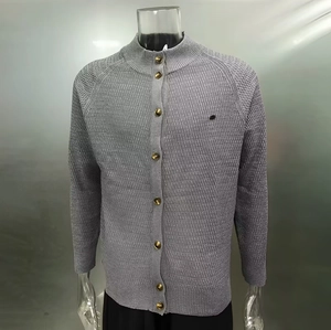 Close-up of gray knit cardigan featuring textured stripe patterns and gold metal buttons