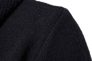 Close-up of the shoulder stitching and dense knit texture on the black cardigan