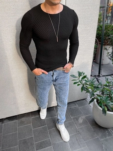 Close-up of slim fit black sweater featuring textured knit patterns and ribbing details