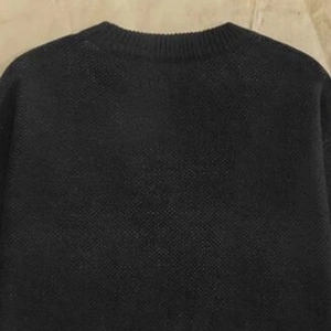 Close-up of the crew neck and fine knit texture of this men's black seasonal sweater