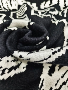Macro view of black and white geometric jacquard knit fabric showing the detailed texture