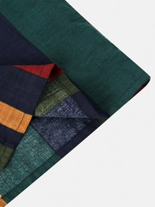 Dettaglio ravvicinato della camicia a righe multicolore con trama in lino e cuciture