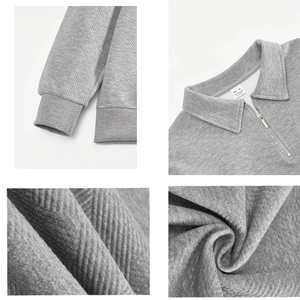 Detailed close-up of grey quarter-zip sweatshirt fabric texture and ribbed cuffs
