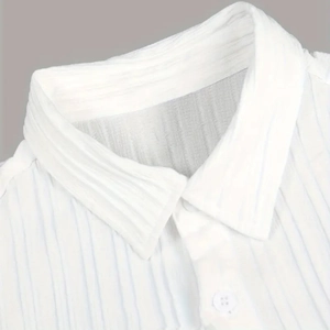 Détail du col d'une chemise à rayures blanches en tissu gaufré respirant et léger