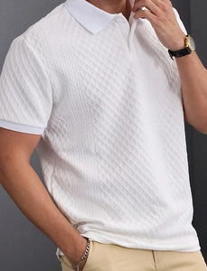 Detailed close-up of men's white polo shirt featuring textured jacquard diamond pattern