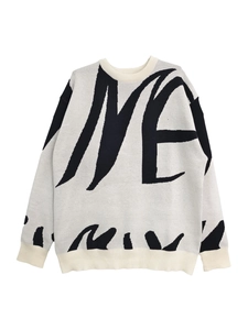 Close-up of ribbed crew neck and black letter jacquard on light gray knit sweater
