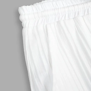 Détail du pantalon plissé blanc pour homme avec taille élastique et tissu texturé