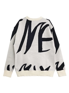 Close-up of crewneck knit sweater with black TIME graffiti lettering and ribbed cuffs