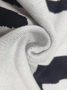 Detailed macro view of black and white color-block knit sweater texture and soft fabric