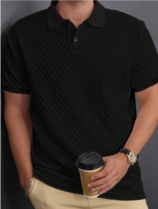 Detailed view of black jacquard knit texture on a men's short-sleeve polo shirt
