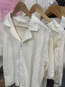 Close-up of white summer sports set featuring textured fabric and lapel shirt detail