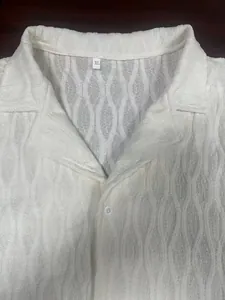 Detail of white men's shirt showing 3D wave texture, XL size label, and button