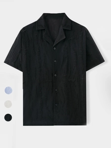 Detail of black Cuban collar shirt featuring unique textured fabric and buttons