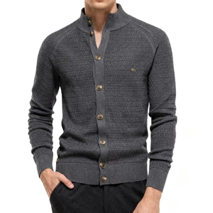 Detail of grey knitted cardigan showing stand collar, metal buttons, and ribbed texture