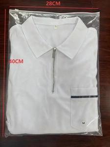 Detailed view of folded white polo shirt in packaging with 28x40cm size dimensions