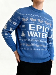 Detail of blue Christmas knit sweater with white snowflake and reindeer pattern