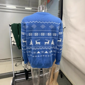 Close-up of blue Christmas knit sweater featuring white snowflakes and reindeer patterns