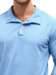 Detail of light blue polo shirt collar featuring pique fabric texture and two white buttons