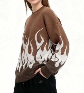 Detailansicht des braunen Strickpullovers mit weißem Flammenmuster an Ärmeln und Saum
