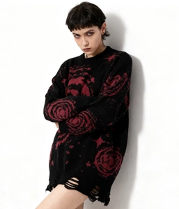 Detailed view of frayed hem and distressed knits on this cosmic punk jacquard sweater