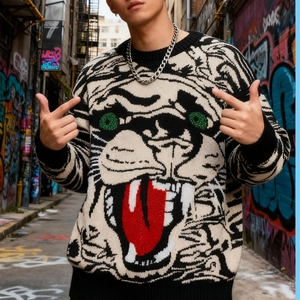 Détail du motif jacquard tête de tigre hip-hop sur pull en maille rayé au style urbain street