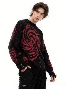 Detail of distressed hem and red galaxy jacquard texture on black knit sweater